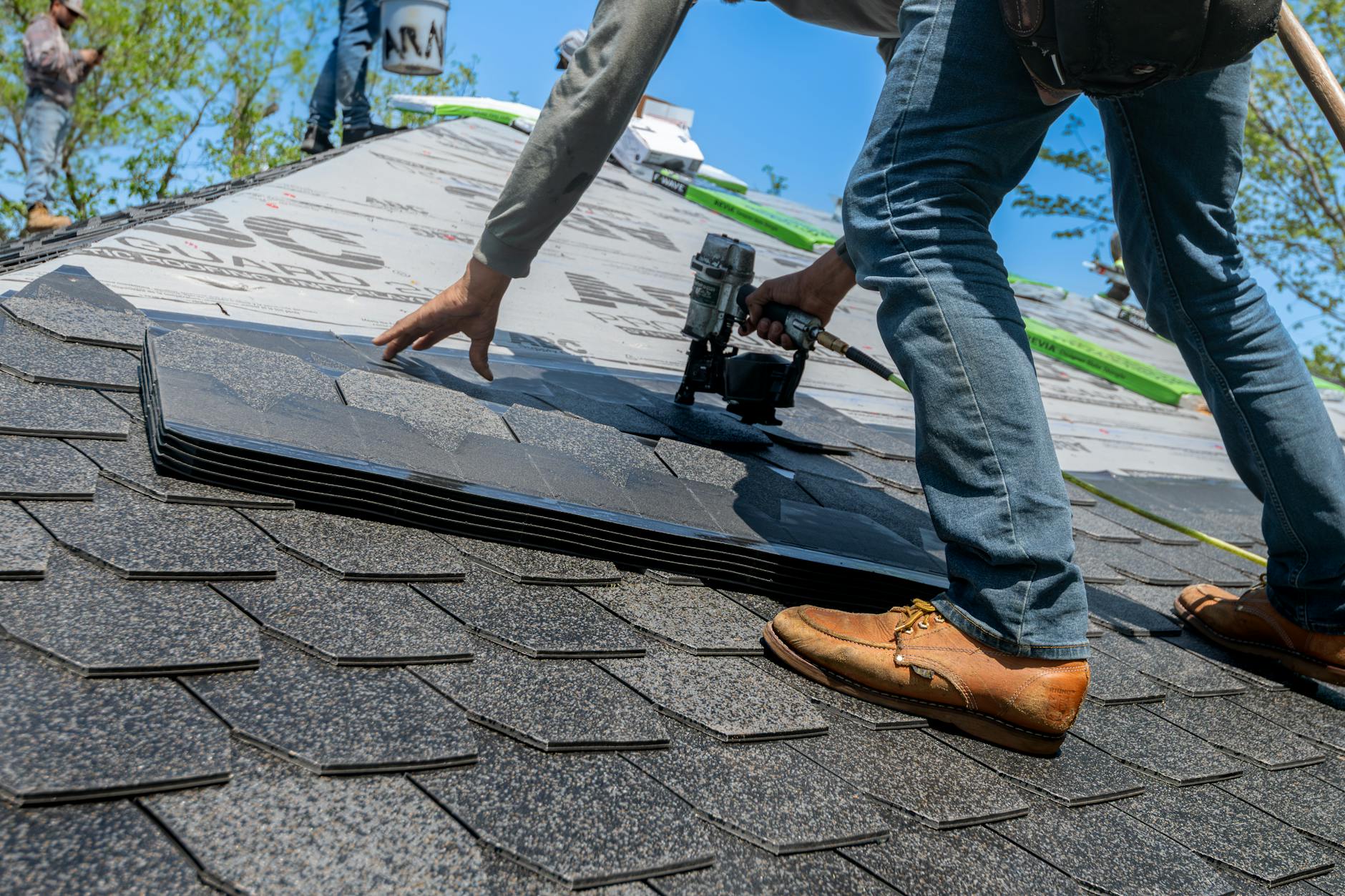 A professional roofer wearing safety gear inspecting a chimney flashing on a brick home in Middletown.